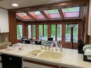 kitchen with white cabinetry, a wealth of natural light, sink, and black dishwasher