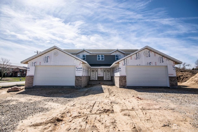 unfinished property featuring a garage and brick siding