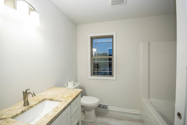 bathroom with vanity, hardwood / wood-style flooring, and toilet