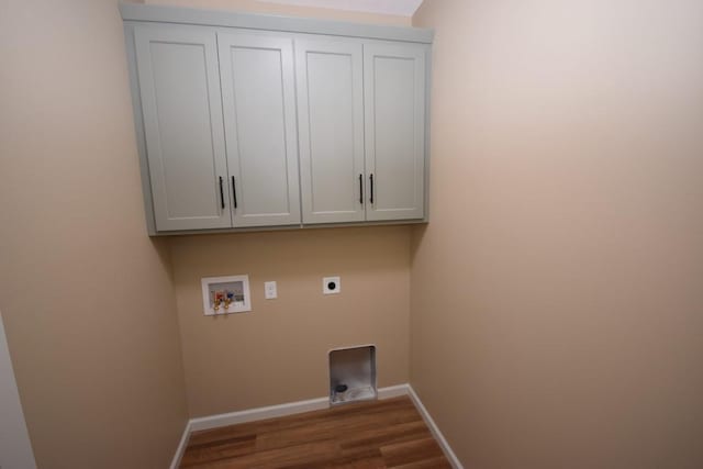 washroom with electric dryer hookup, cabinets, dark wood-type flooring, and hookup for a washing machine