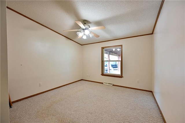 carpeted empty room featuring ceiling fan, a textured ceiling, and ornamental molding