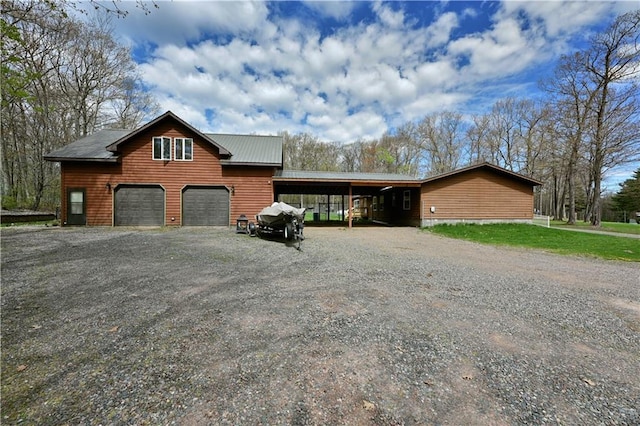 view of front of home with a garage and a carport