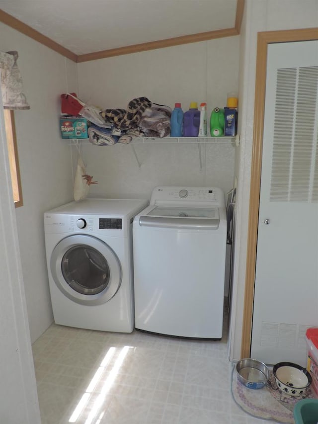 laundry room with crown molding, independent washer and dryer, and light tile floors