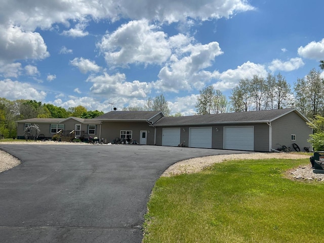 ranch-style house with a garage and a front lawn