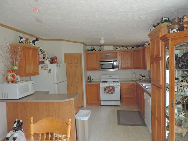 kitchen with a textured ceiling, lofted ceiling, white appliances, kitchen peninsula, and light tile floors