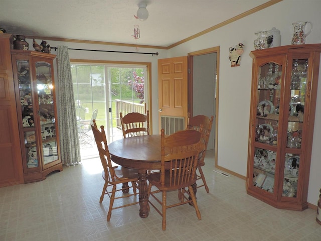 tiled dining space featuring ornamental molding