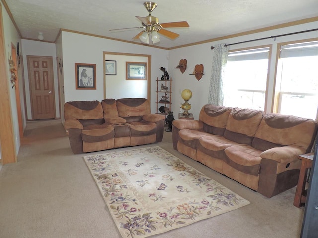 carpeted living room featuring ornamental molding and ceiling fan