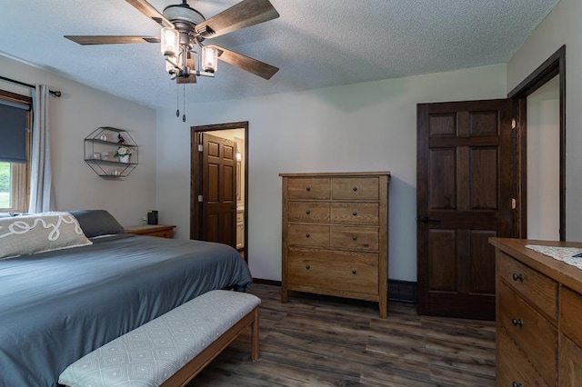 bedroom featuring dark wood-type flooring, ceiling fan, ensuite bath, and a textured ceiling