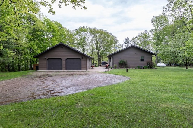 view of side of home featuring a yard, a garage, and an outdoor structure