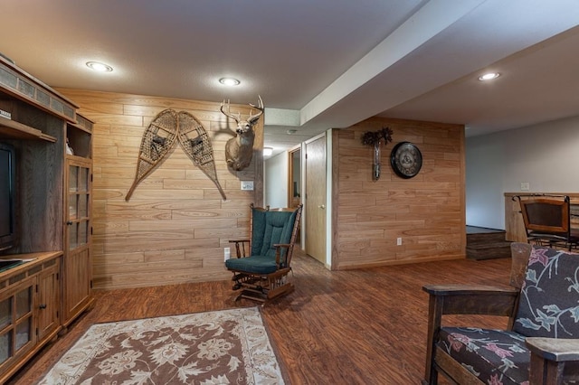 living room with hardwood / wood-style flooring and wood walls