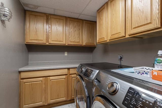 washroom featuring cabinets and washing machine and dryer