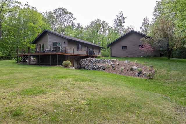 rear view of house featuring a wooden deck and a lawn