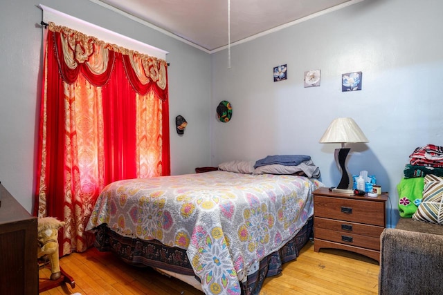 bedroom featuring hardwood / wood-style flooring and ornamental molding