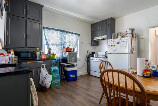 kitchen with dark hardwood / wood-style flooring and white appliances