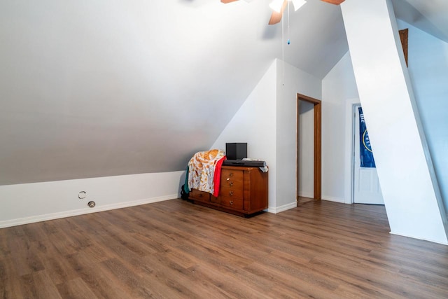 additional living space with ceiling fan, vaulted ceiling, and dark hardwood / wood-style flooring