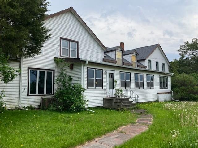 rear view of property featuring a lawn