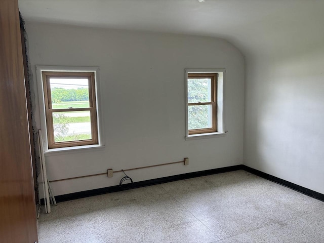 spare room with vaulted ceiling and a healthy amount of sunlight