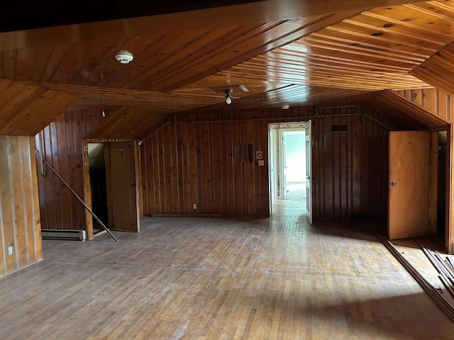 bonus room featuring baseboard heating, light hardwood / wood-style floors, lofted ceiling, wooden walls, and wood ceiling