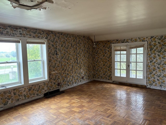 spare room featuring plenty of natural light, parquet floors, and french doors