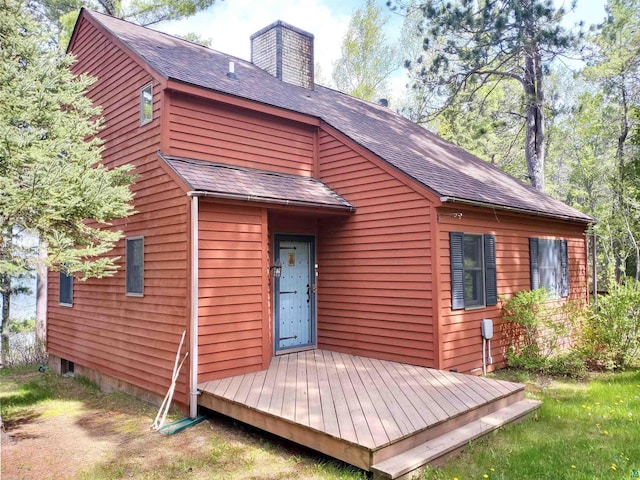 rear view of property featuring a wooden deck