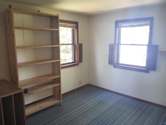 unfurnished bedroom with dark carpet