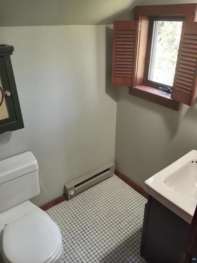 bathroom featuring tile flooring, baseboard heating, vanity, and toilet