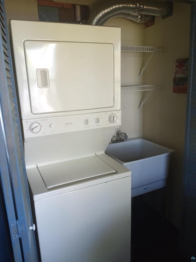 clothes washing area with stacked washer and dryer and sink