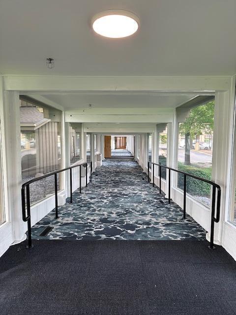 hallway featuring dark colored carpet