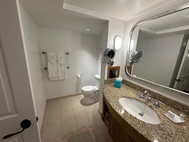 bathroom with tile flooring, large vanity, and toilet