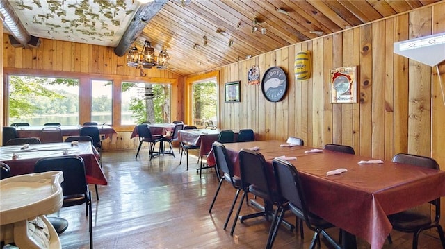 14549 Plummer Rd, Weyerhaeuser, WI 54895 - dining space featuring an inviting chandelier, wood walls, vaulted ceiling, and hardwood / wood-style floors