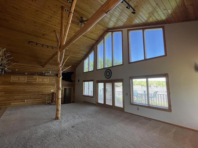 unfurnished living room with carpet floors, a fireplace, rail lighting, and wooden ceiling