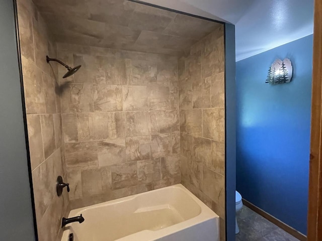 bathroom with tiled shower / bath combo and toilet