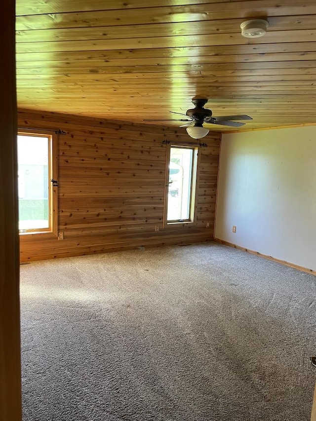 carpeted spare room with wooden walls, wooden ceiling, and lofted ceiling