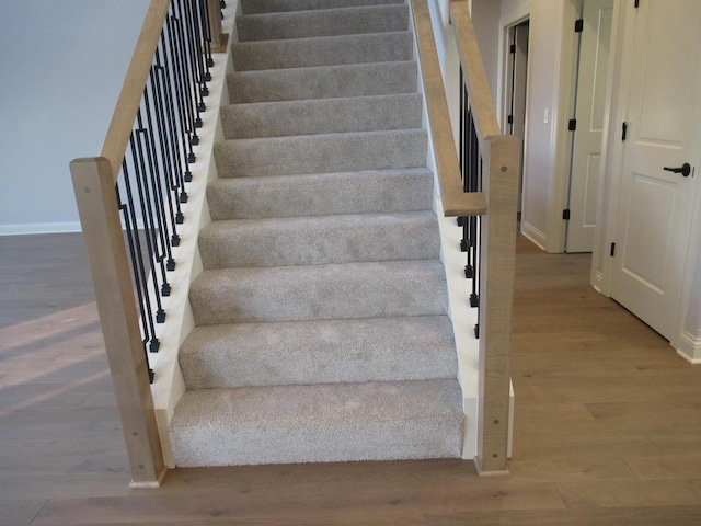 stairway with hardwood / wood-style floors