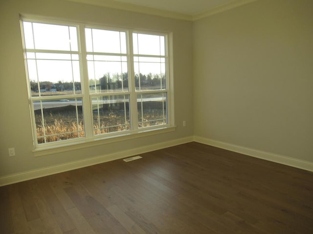 empty room with ornamental molding and dark hardwood / wood-style flooring