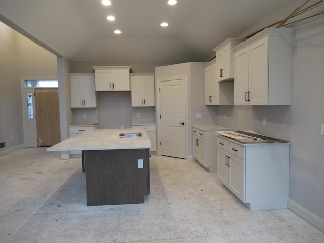 kitchen with white cabinetry, lofted ceiling, and a center island