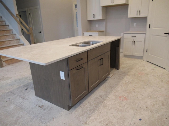 kitchen featuring dark brown cabinetry, sink, white cabinets, and a kitchen island