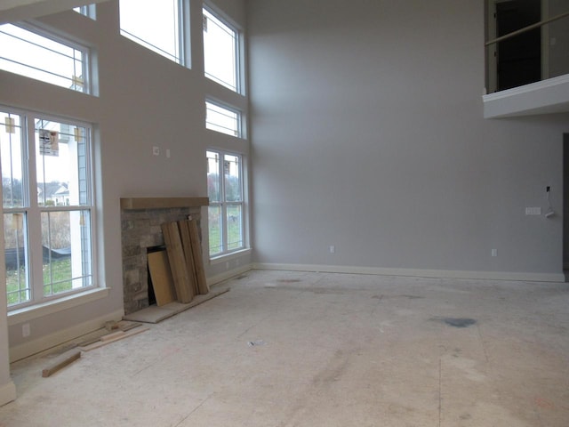 unfurnished living room featuring a high ceiling and a fireplace