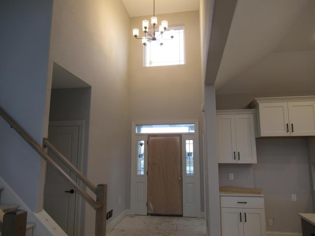 foyer with a towering ceiling and a notable chandelier