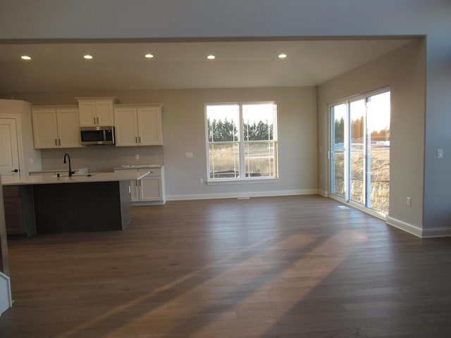 kitchen with tasteful backsplash, dark hardwood / wood-style floors, sink, and white cabinets