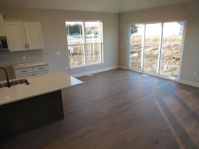 kitchen featuring a healthy amount of sunlight, sink, white cabinets, and dark hardwood / wood-style floors