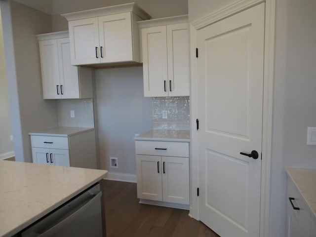 kitchen featuring white cabinetry, stainless steel dishwasher, backsplash, and dark hardwood / wood-style flooring