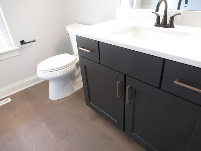 bathroom with hardwood / wood-style flooring, vanity, and toilet