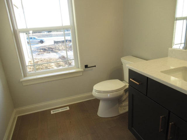 bathroom featuring vanity, hardwood / wood-style floors, and toilet