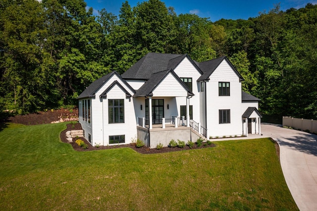 view of front of house featuring covered porch and a front lawn