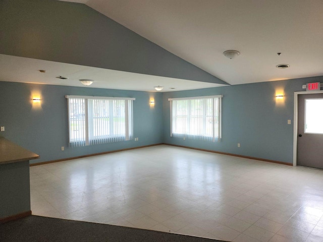 unfurnished living room with high vaulted ceiling and a wealth of natural light