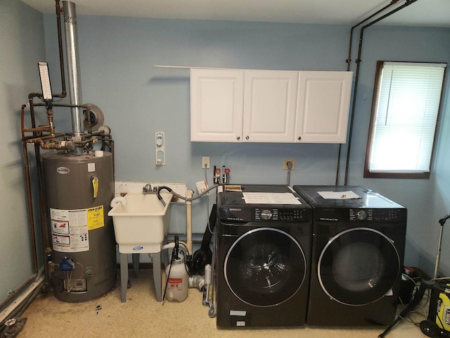 washroom with washing machine and clothes dryer, water heater, sink, and cabinets