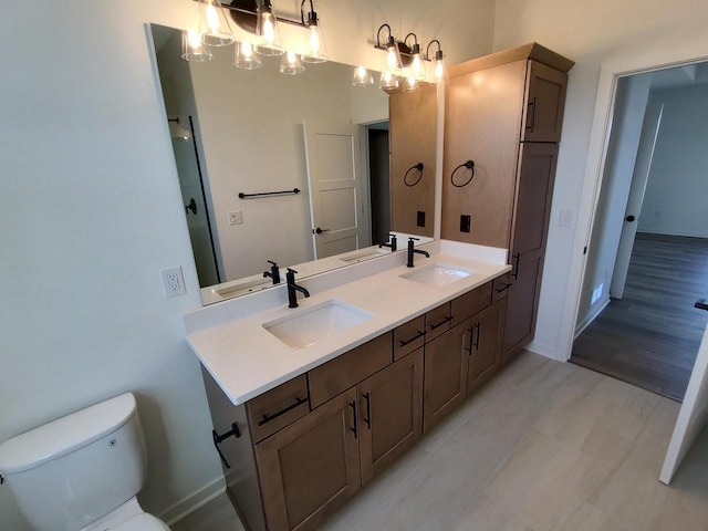 485 Chapman Farm Blvd, Mukwonago, WI 53149 - full bath featuring a chandelier, baseboards, toilet, and double vanity