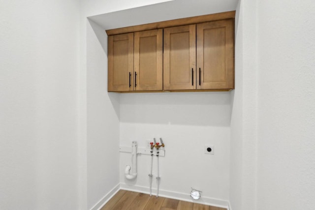 485 Chapman Farm Blvd, Mukwonago, WI 53149 - clothes washing area with gas dryer hookup, baseboards, light wood-style floors, cabinet space, and hookup for an electric dryer