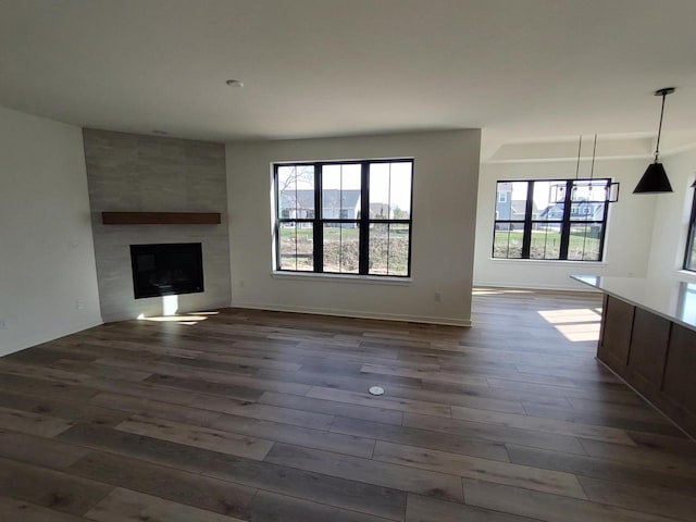 485 Chapman Farm Blvd, Mukwonago, WI 53149 - unfurnished living room featuring dark wood-style floors and a large fireplace